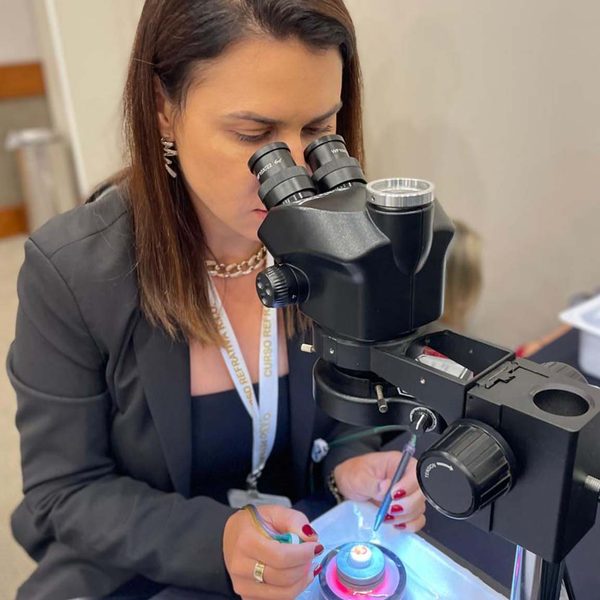 Dra. Cintia em treinamento cirúrgico ao microscópio